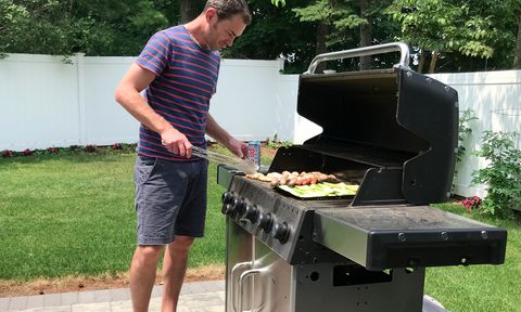 Man using an outdoor grill.