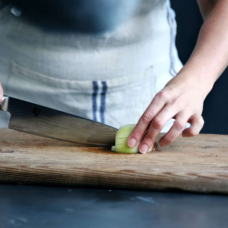 knife cutting onions board