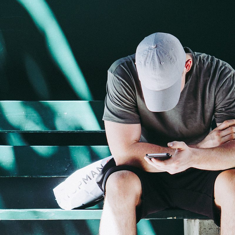 man sitting face down while texting.