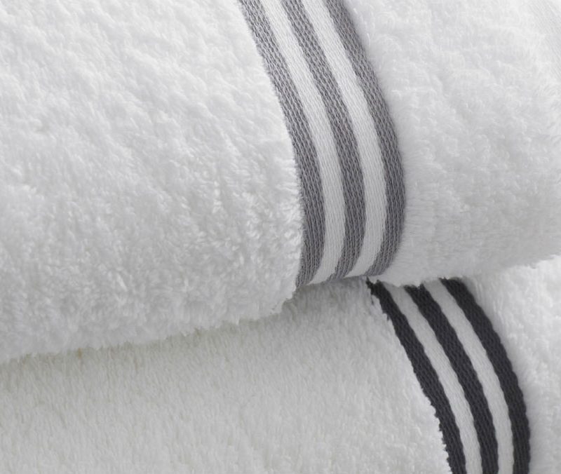 Two white towels with respective gray and black outline on top of one another.