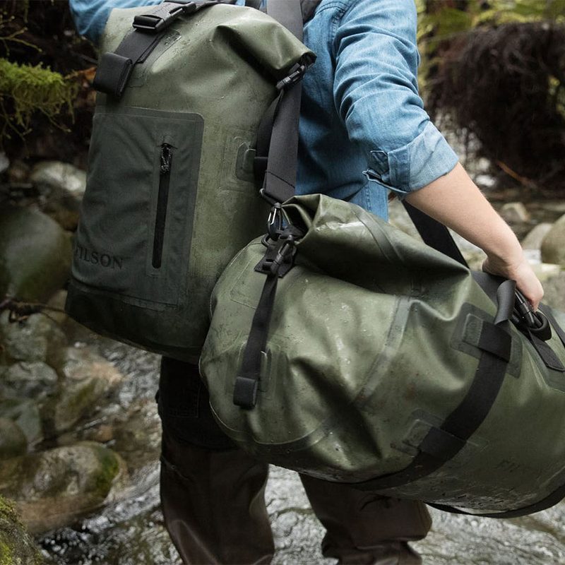 A man carrying two bags while trekking.
