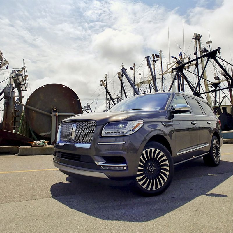Lincoln Navigator Black Label front end from passenger's side in a shipyard.