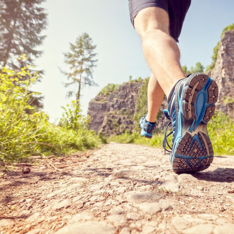 Close-up shot of trail running shoes on rocky trail.