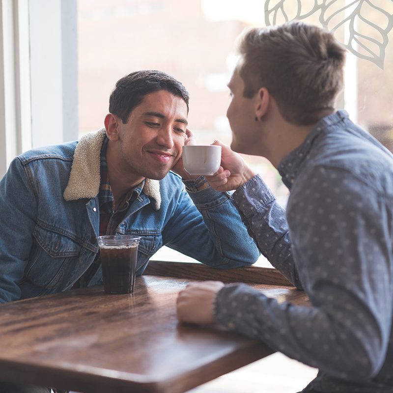 Young gay couple in coffee house