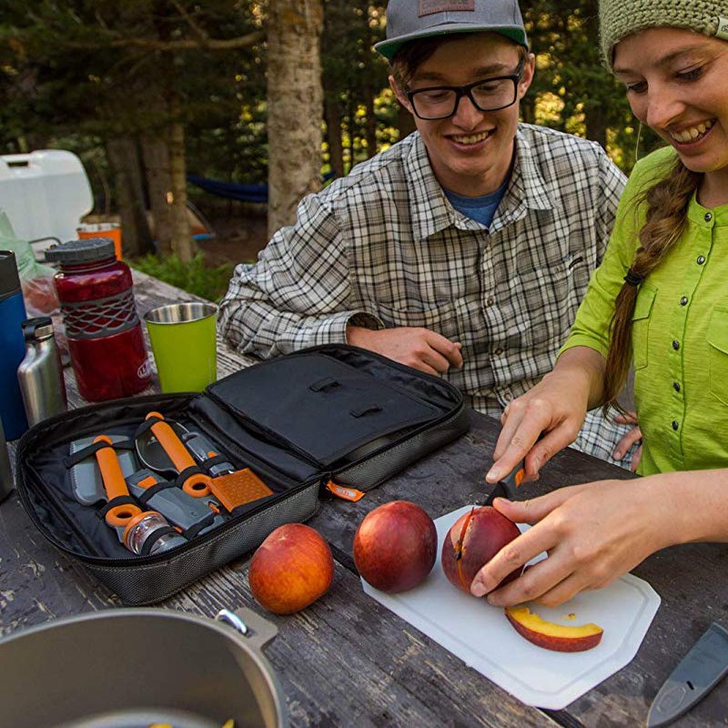 A girl cutting apples on a chopping board outdoor.