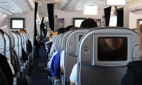 The inside of the cabin of an airplane full of passengers