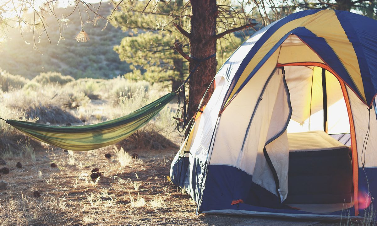 An opened tent in the outdoors during a sunny day.