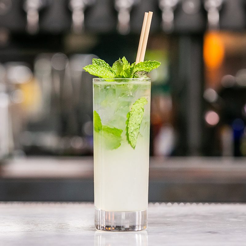 A mojito cocktail sitting on the bar