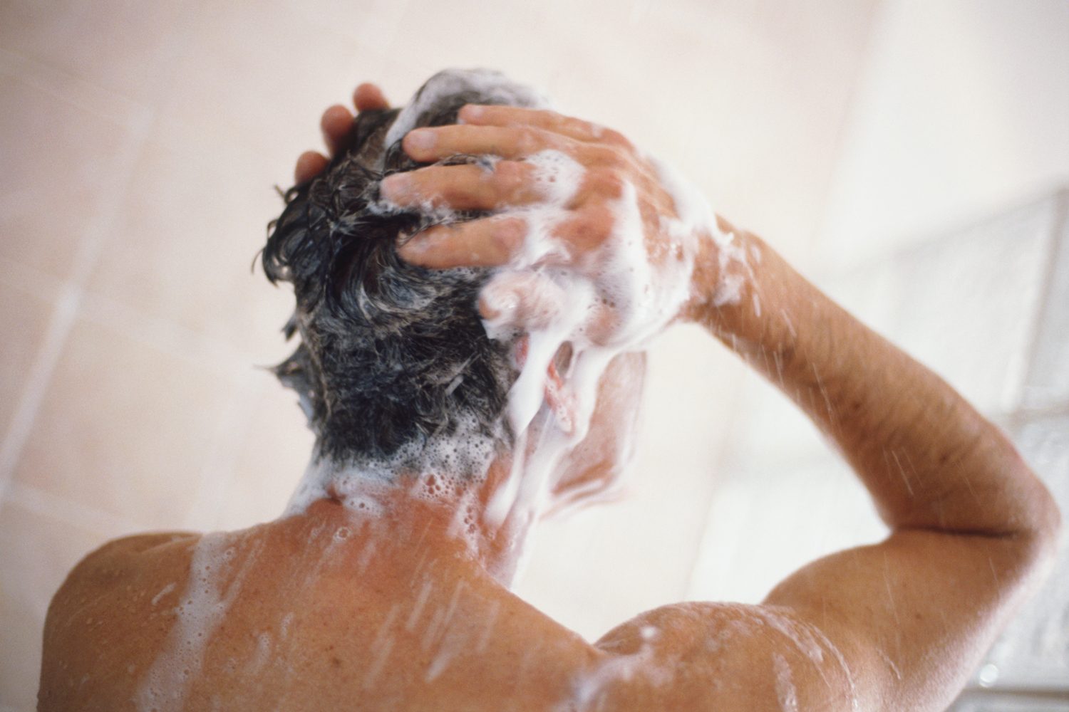 Man washing hair in the shower.