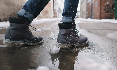 Person wearing pair of gray leather boots