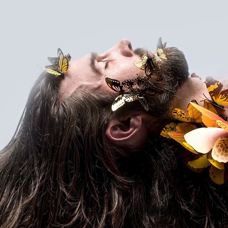 Brett Stout with long hair covered in butterflies