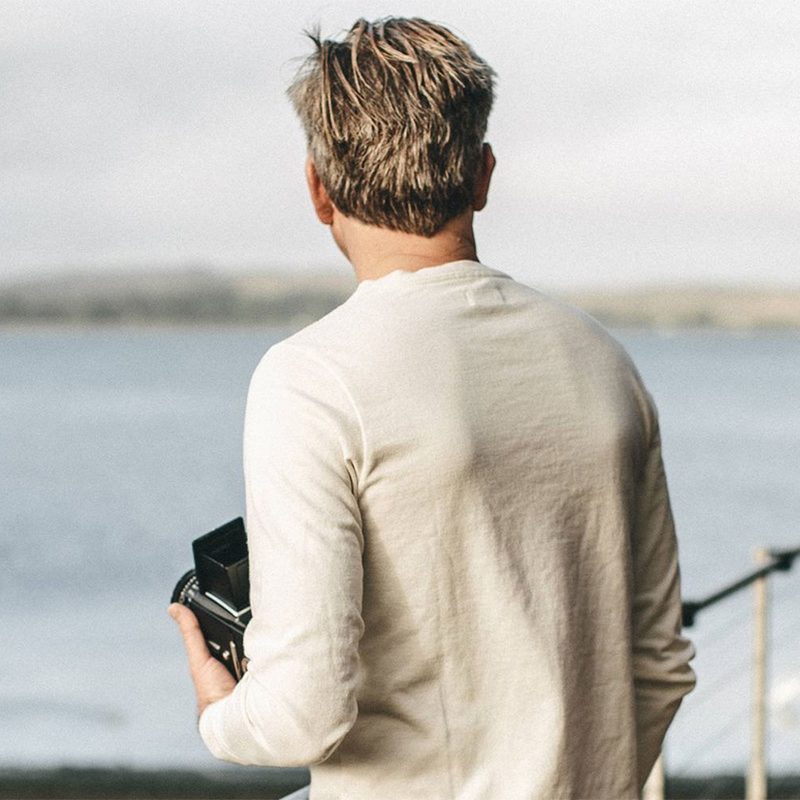 man in a henley shirt staring over the ocean.