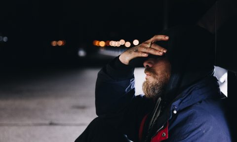 Man sitting on the ground looking sad