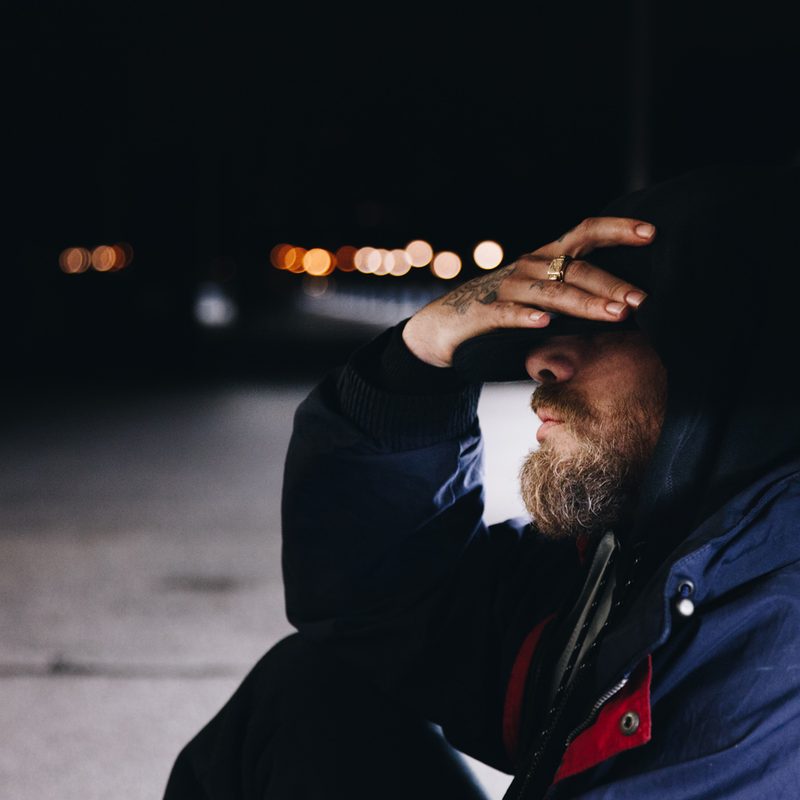 Man sitting on the ground looking sad