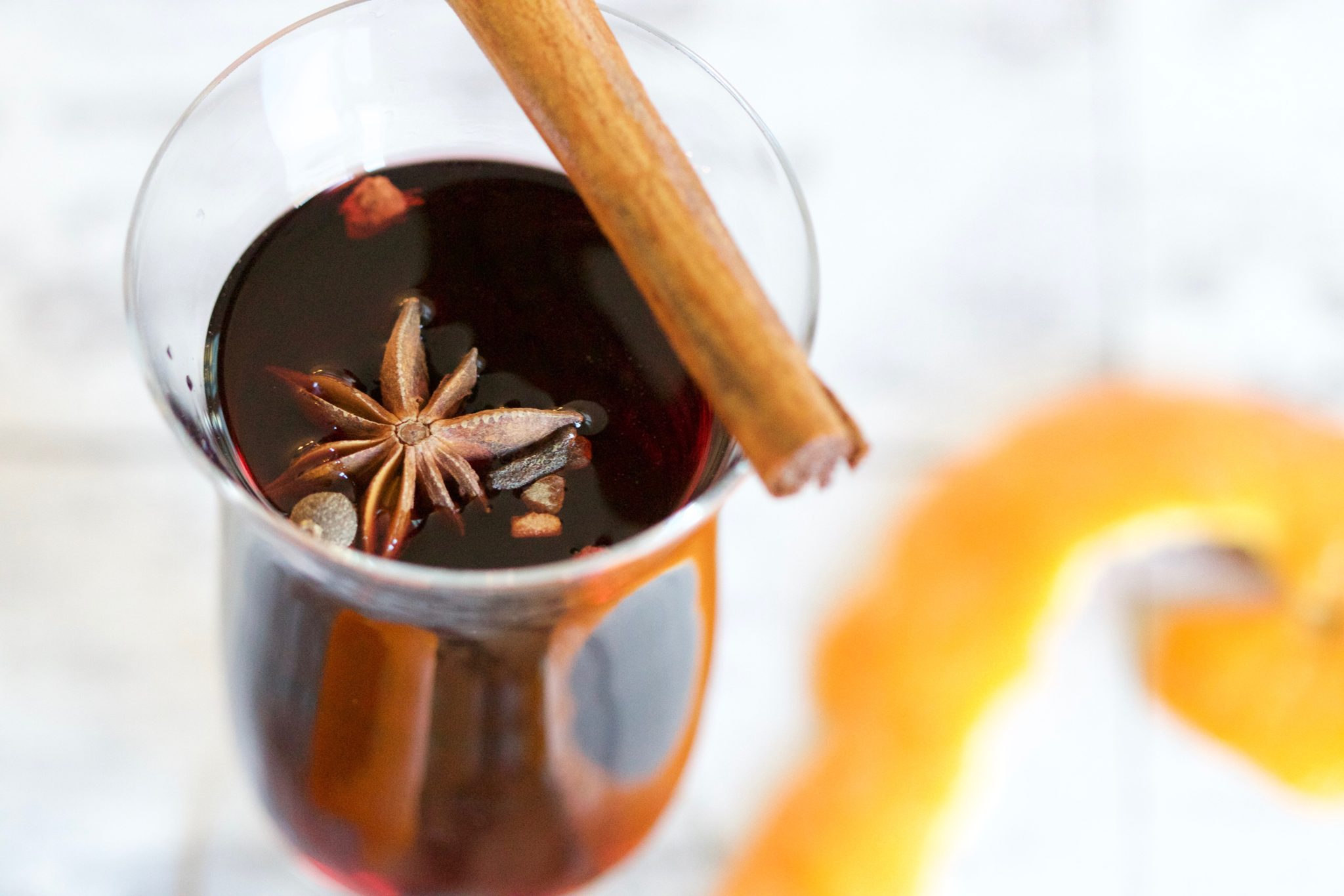 Glass of mulled wine with a cinnamon stick on top