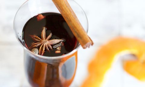 Glass of mulled wine with a cinnamon stick on top