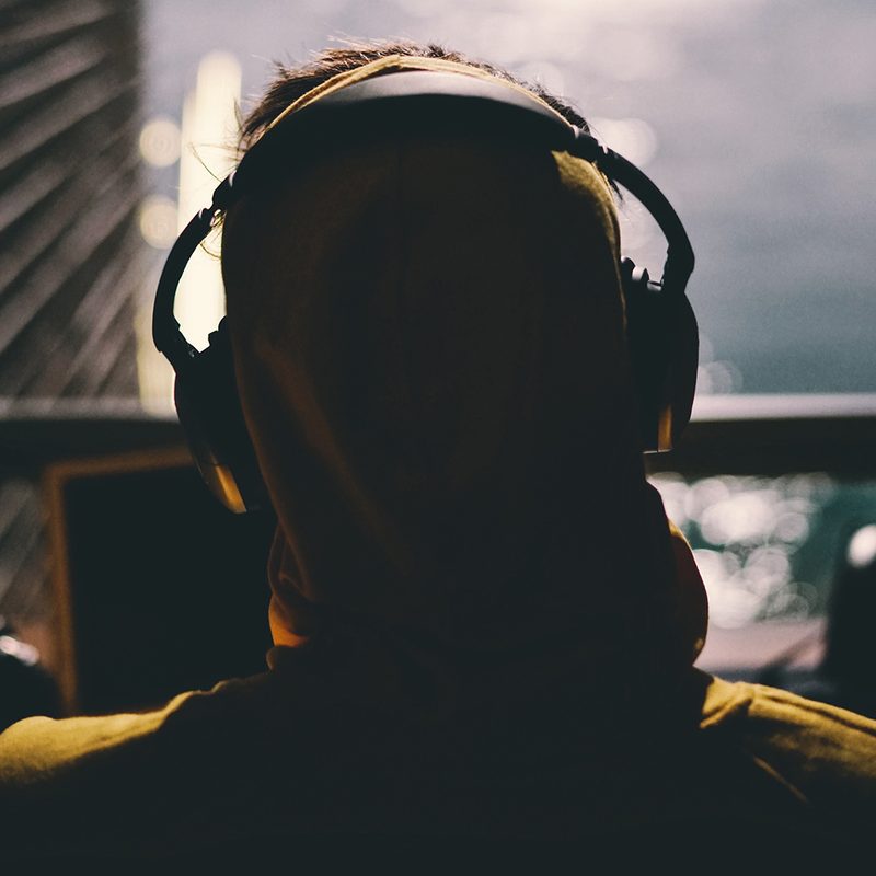 Wearing headphones listing to a podcast on a laptop