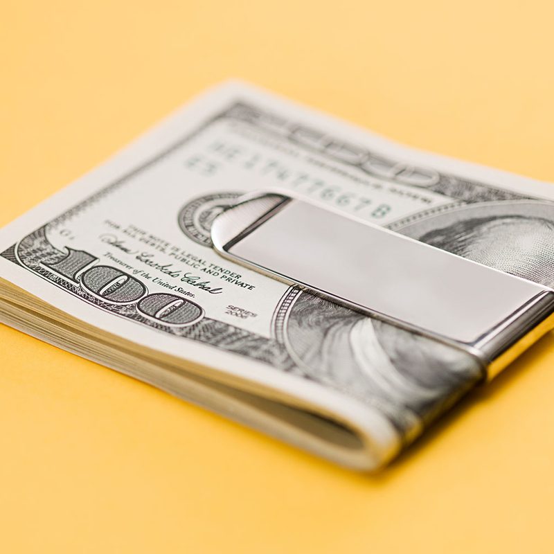 $100 bills folded into a metal money clip