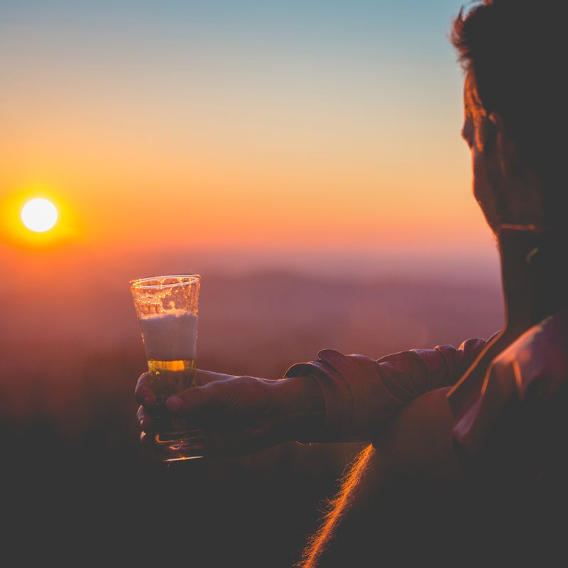 Man drinking at sunset.