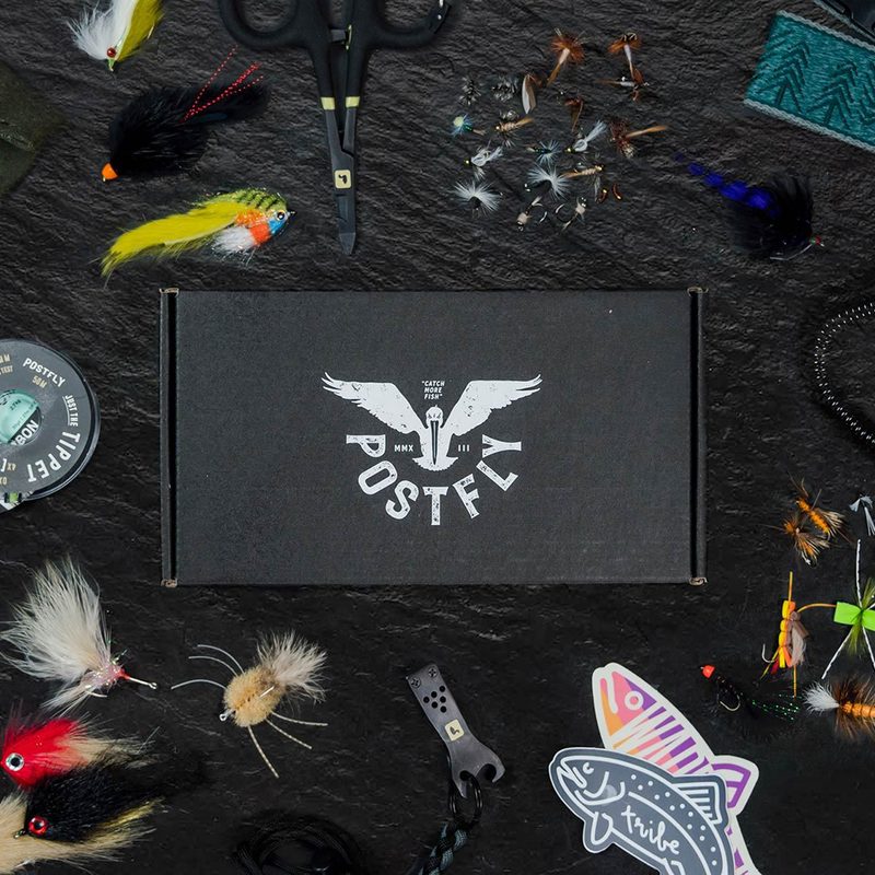 Flatlay of the Postfly box with fly-fishing tools.