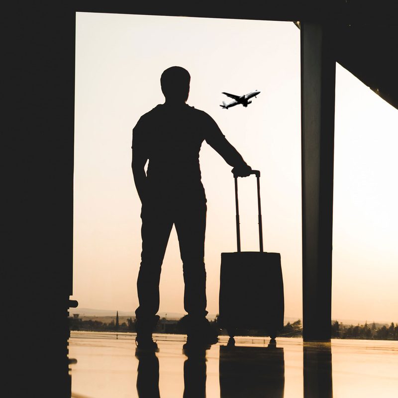 Traveler watching planes from an airport window.