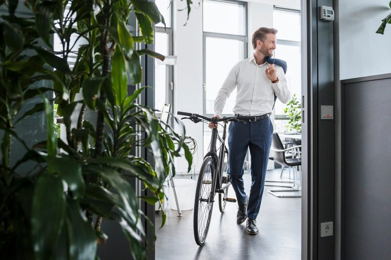 man in suit commuting in to work on bike