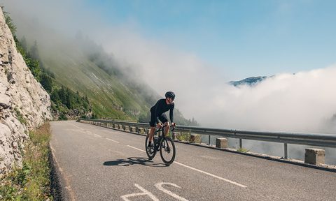 man cycling through France on road blue sky in background