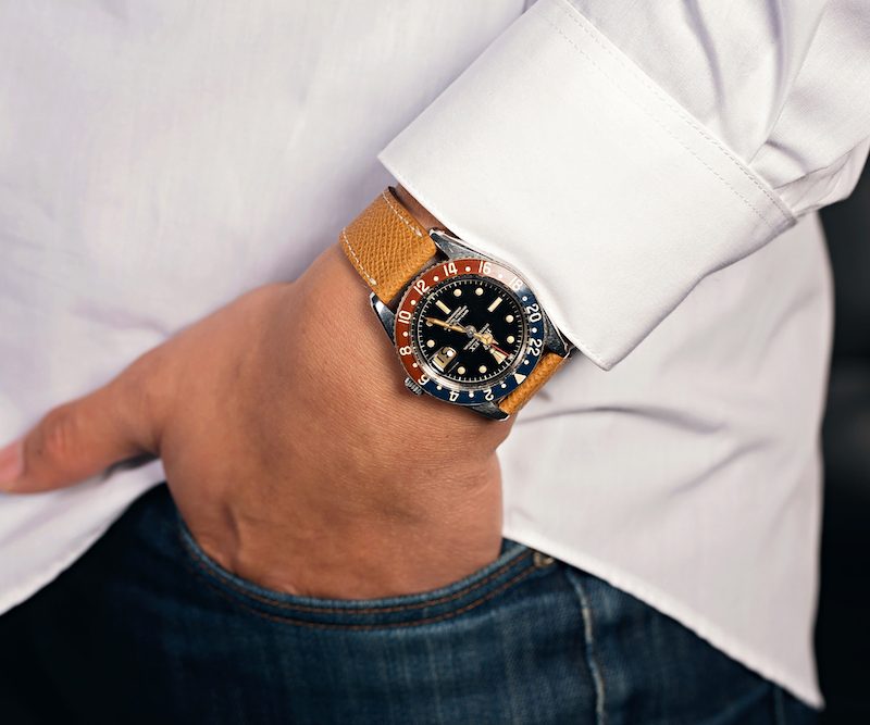 Man in white shirt with a Rolex watch and hand in pocket
