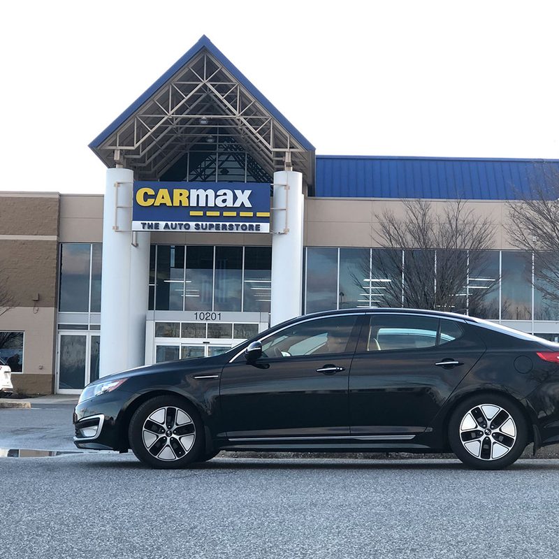 Car parked in front of Carmax building.