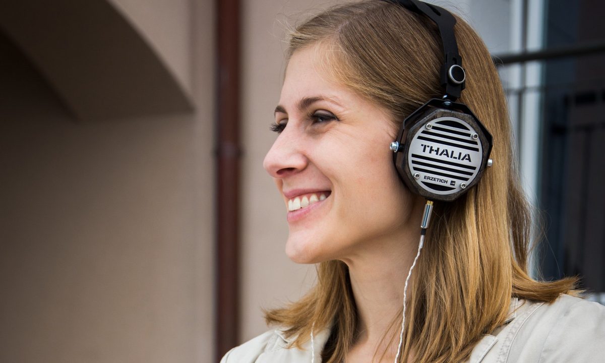 woman listening to podcast and smiling