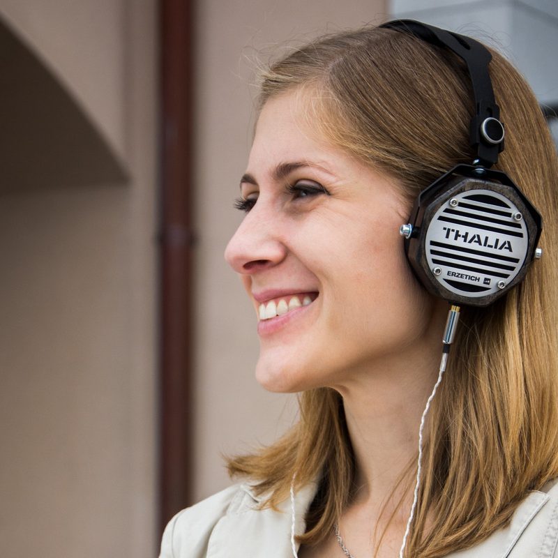 woman listening to podcast and smiling