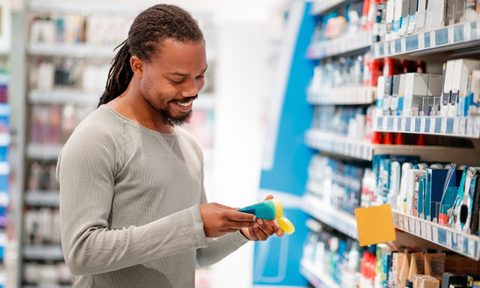 Man choosing hair product in department store.