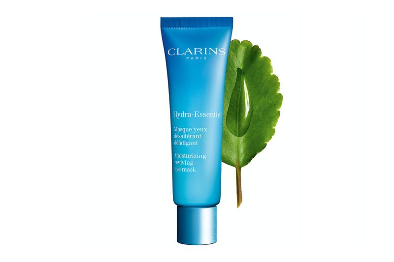 A tube of Clarins Hydra-Essentiel Moisturizing Reviving Eye Mask with the Leaf of Life behind it.