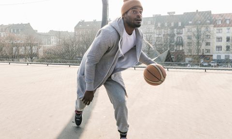 Man wearing athletic outfit while playing basketball.