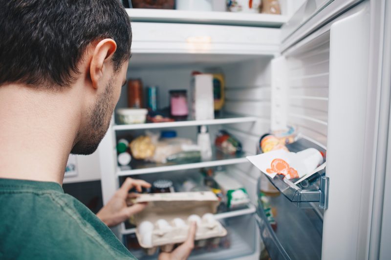 man looking in fridge
