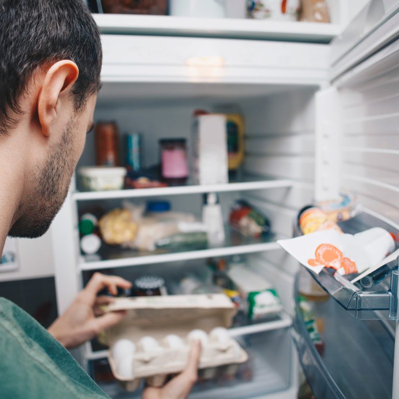 man looking in fridge