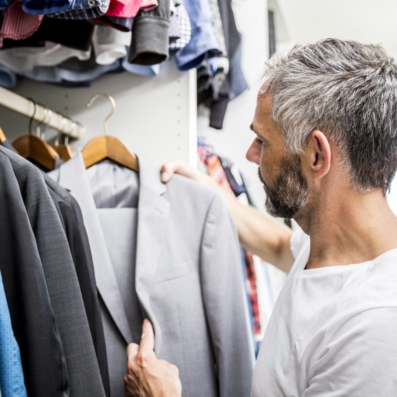 Man choosing clothes at his walk-in closet