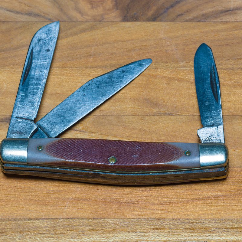 multi blade knife sitting on a table.
