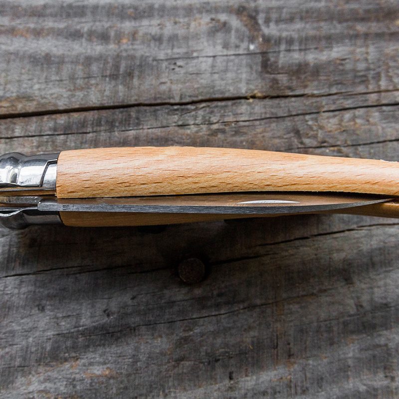 penknife sitting on a wood table.