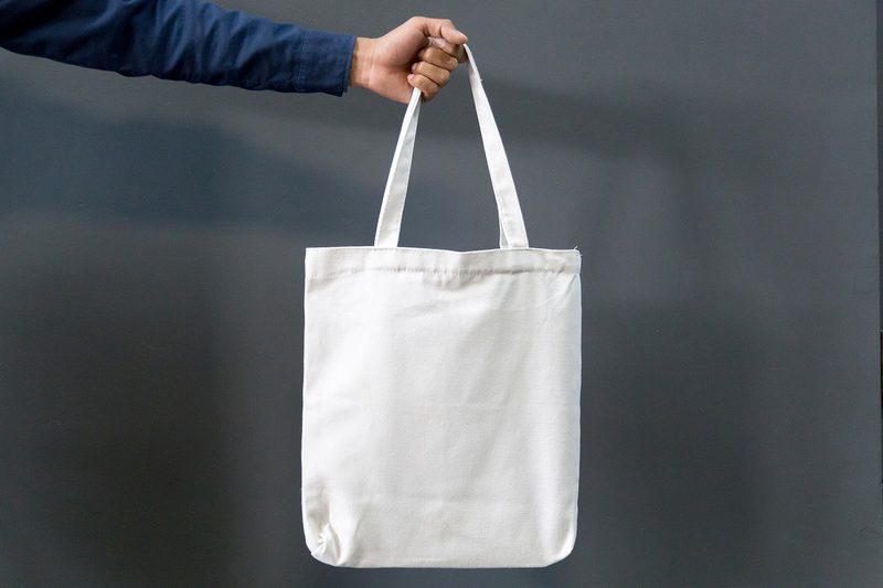 man holding tote bag