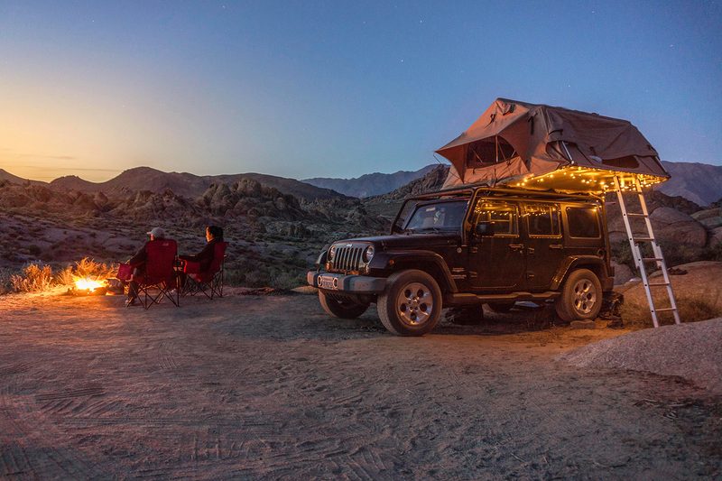 rooftop tent attached to jeep at campsite.