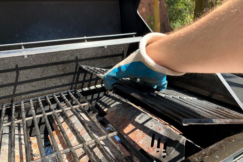 A person removes grill grates