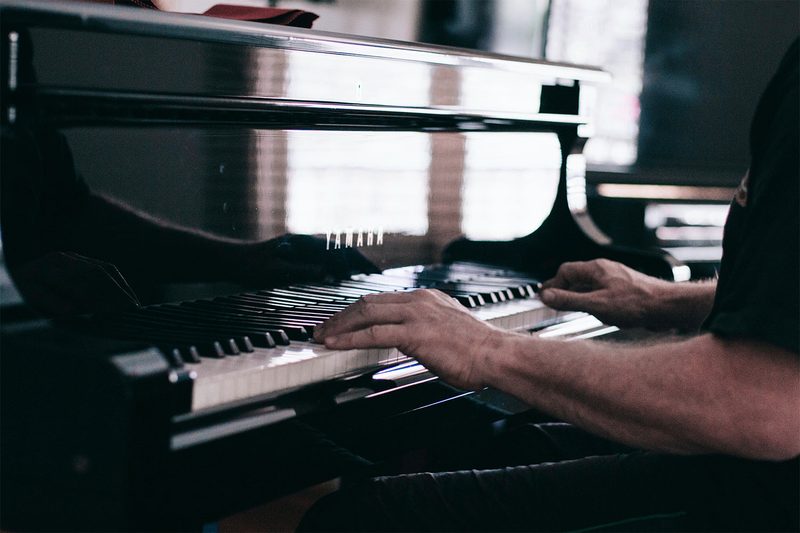 Man playing a black piano.