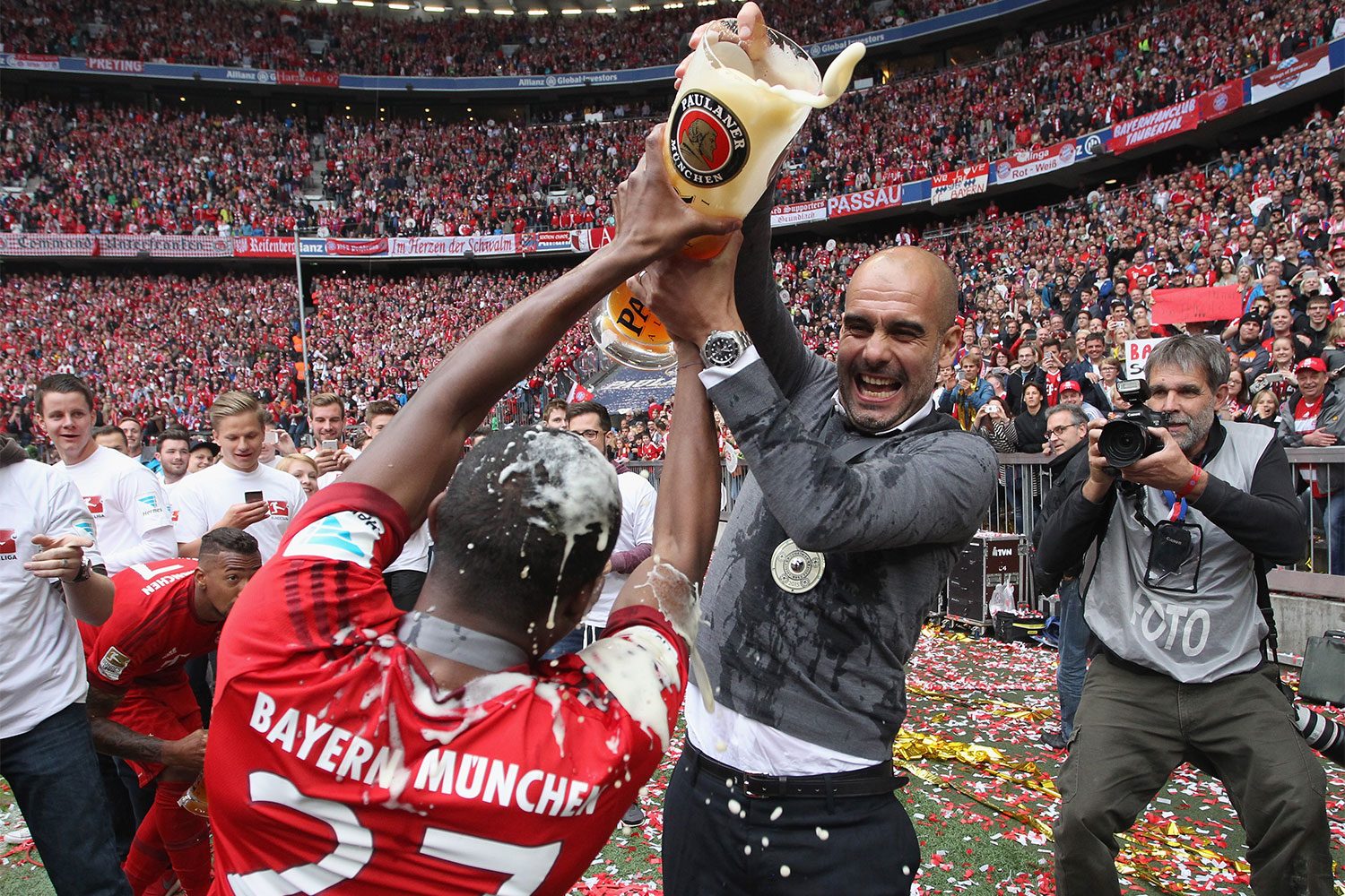 Man pouring beer on a soccer player during a celebration