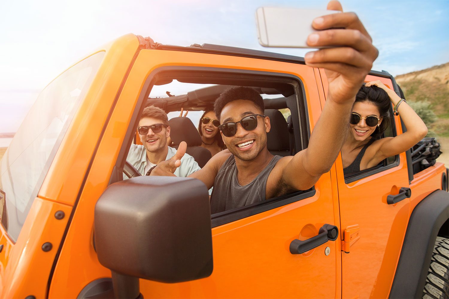 people in an orange car during a road trip
