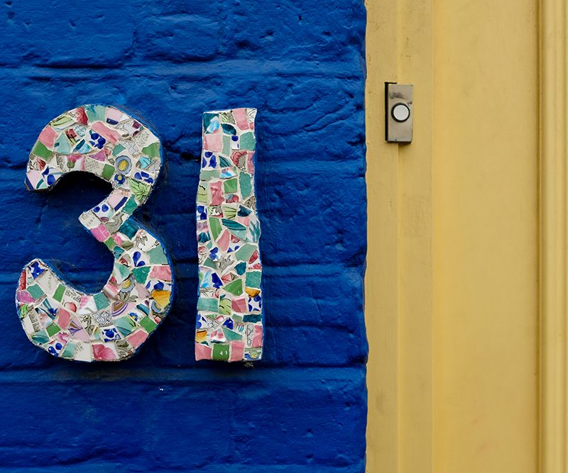 A colorful house number "31" on brick wall at Portobello Road.