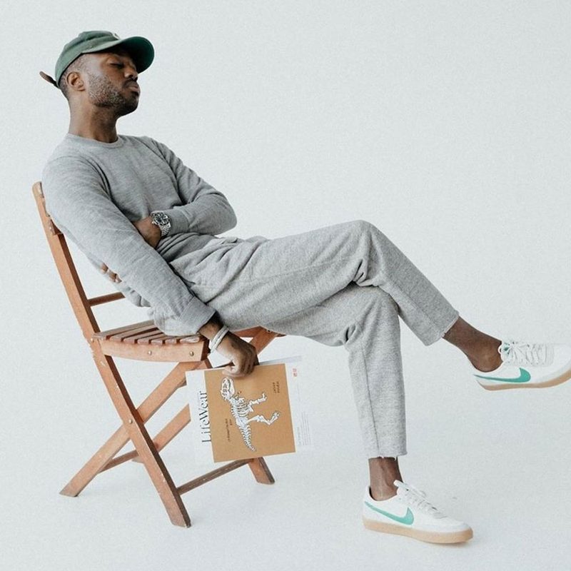 Man wearing Uniqlo clothing, sitting in a chair.