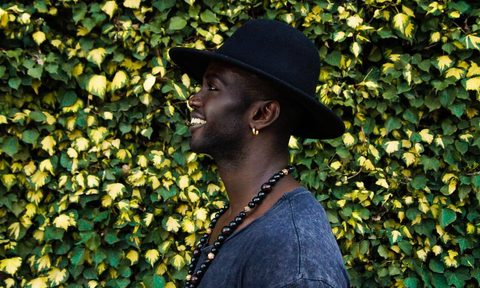 Man wearing earrings as part of his outfit.