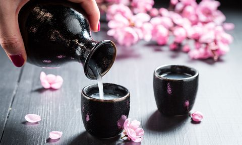 Female hand pouring sake