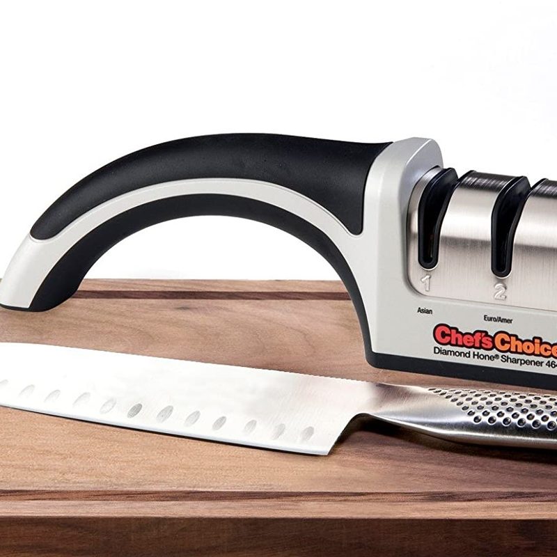 Chef's choice knife sharpener sitting next to a global knife on a cutting board.